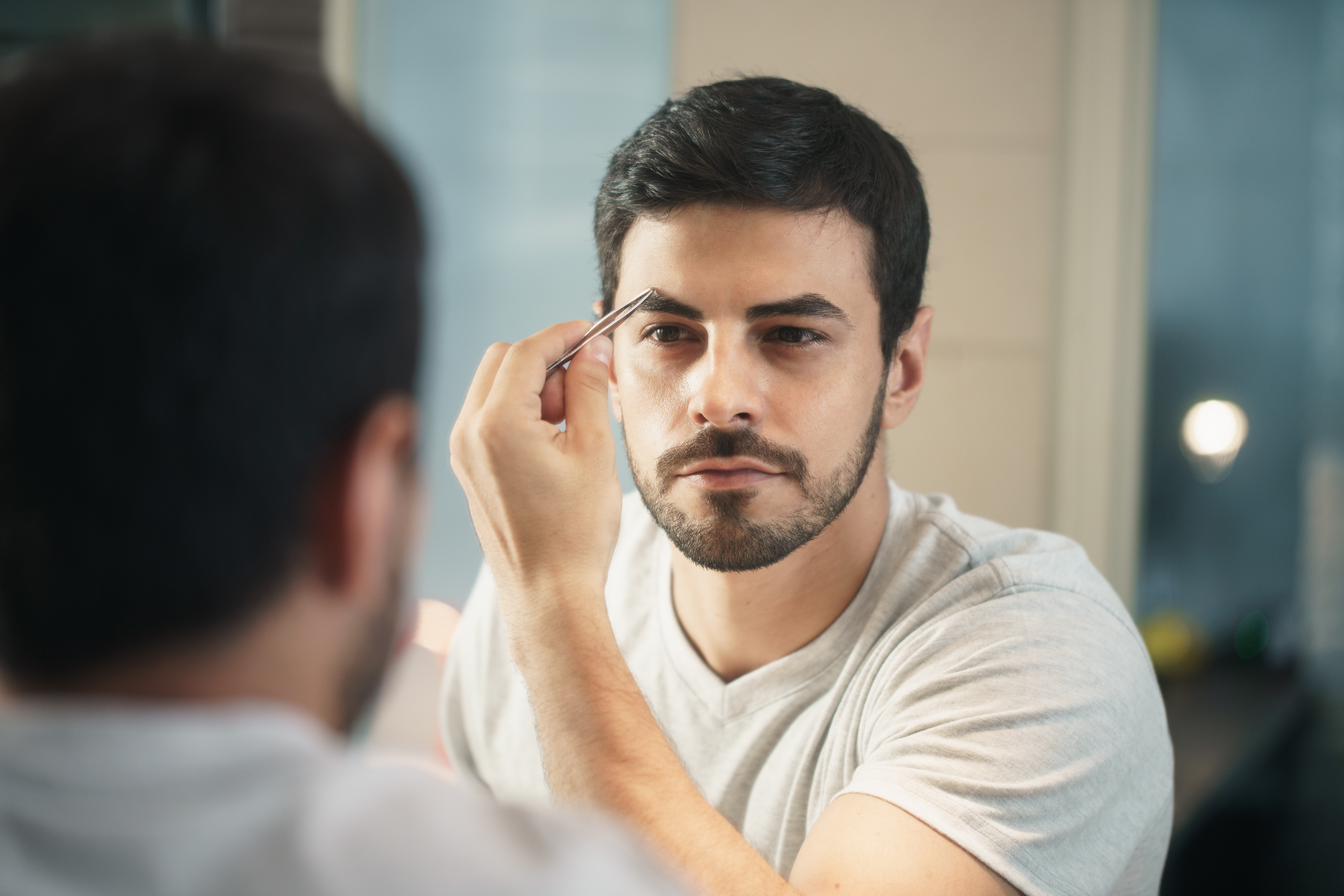 latino man trimming eyebrow for body care in nxbdas5 - beauty salons near me directory